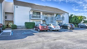 Un motel à plusieurs étages doté d’un parking, avec un escalier central et un petit balcon au deuxième étage.