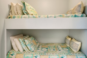 Uma cama beliche com edredom acolchoado e travesseiros.