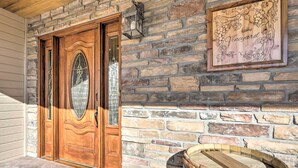 A wooden door with a glass panel, a stone wall, and a framed sign that reads "The Vineyard". - The Vineyard Country Farm Home at Grand Valley (Grand Junction)