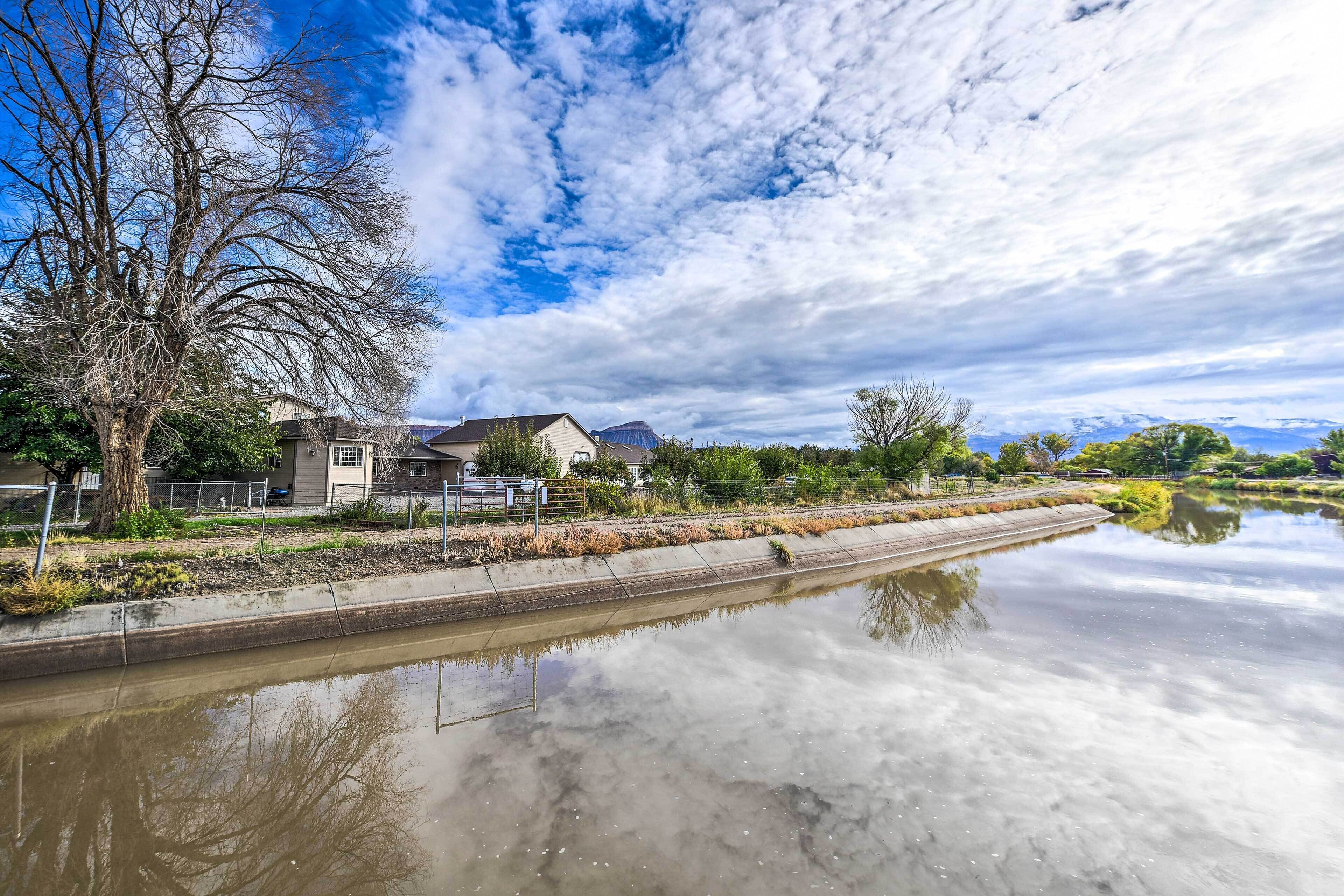 Un canal con una casa a la izquierda y un cielo despejado.