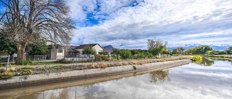 Un canal con una casa a la izquierda y un cielo despejado.