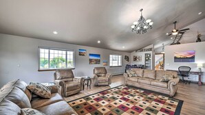 A spacious living room with leather sofas, a patterned rug, and artwork on the walls. - The Vineyard Country Farm Home at Grand Valley (Grand Junction)