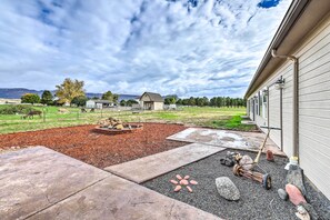 A landscaped backyard with a fire pit, stone pathway, and a small pond.