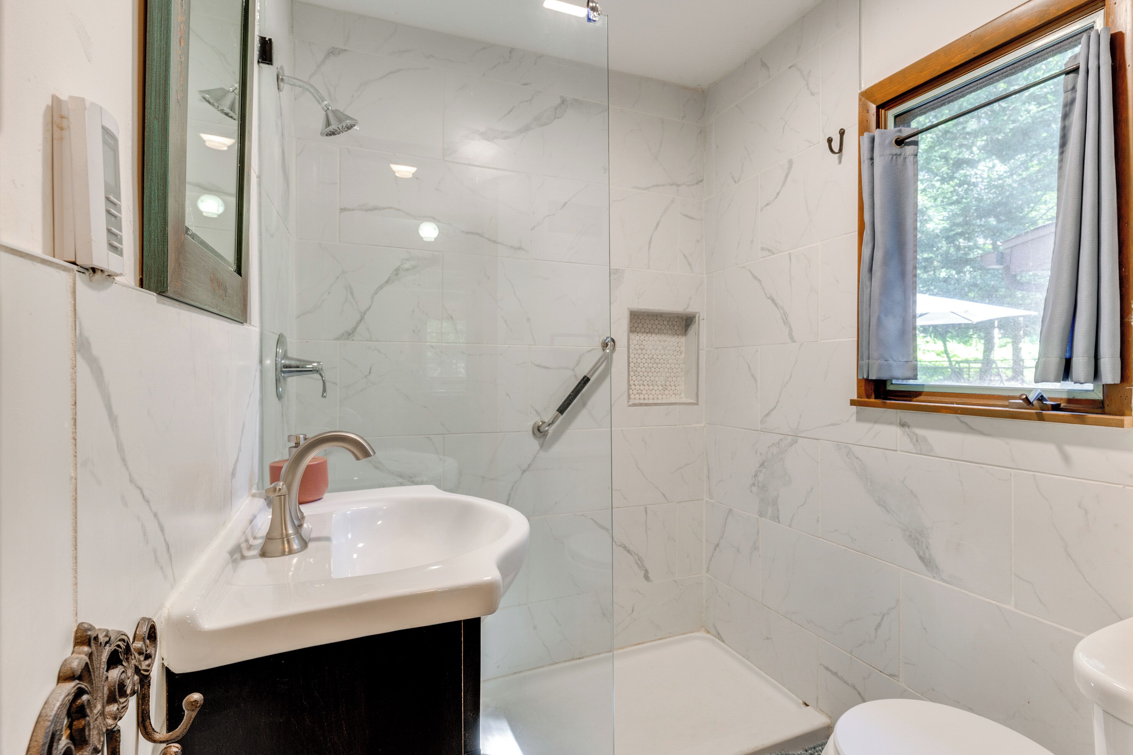 A bathroom with a white sink, a shower, and a toilet.