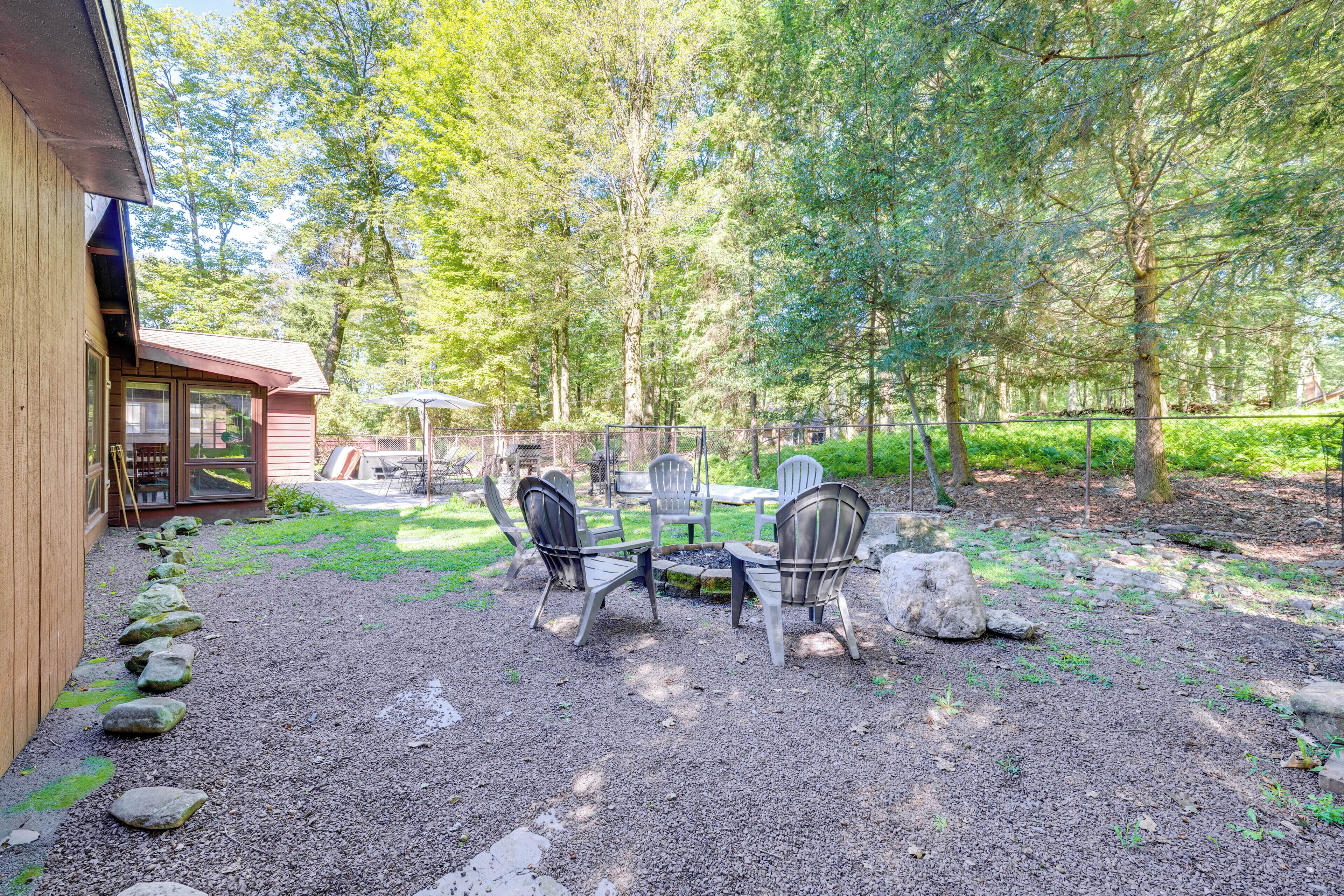 A patio with outdoor furniture, a fire pit, and a wooden cabin.