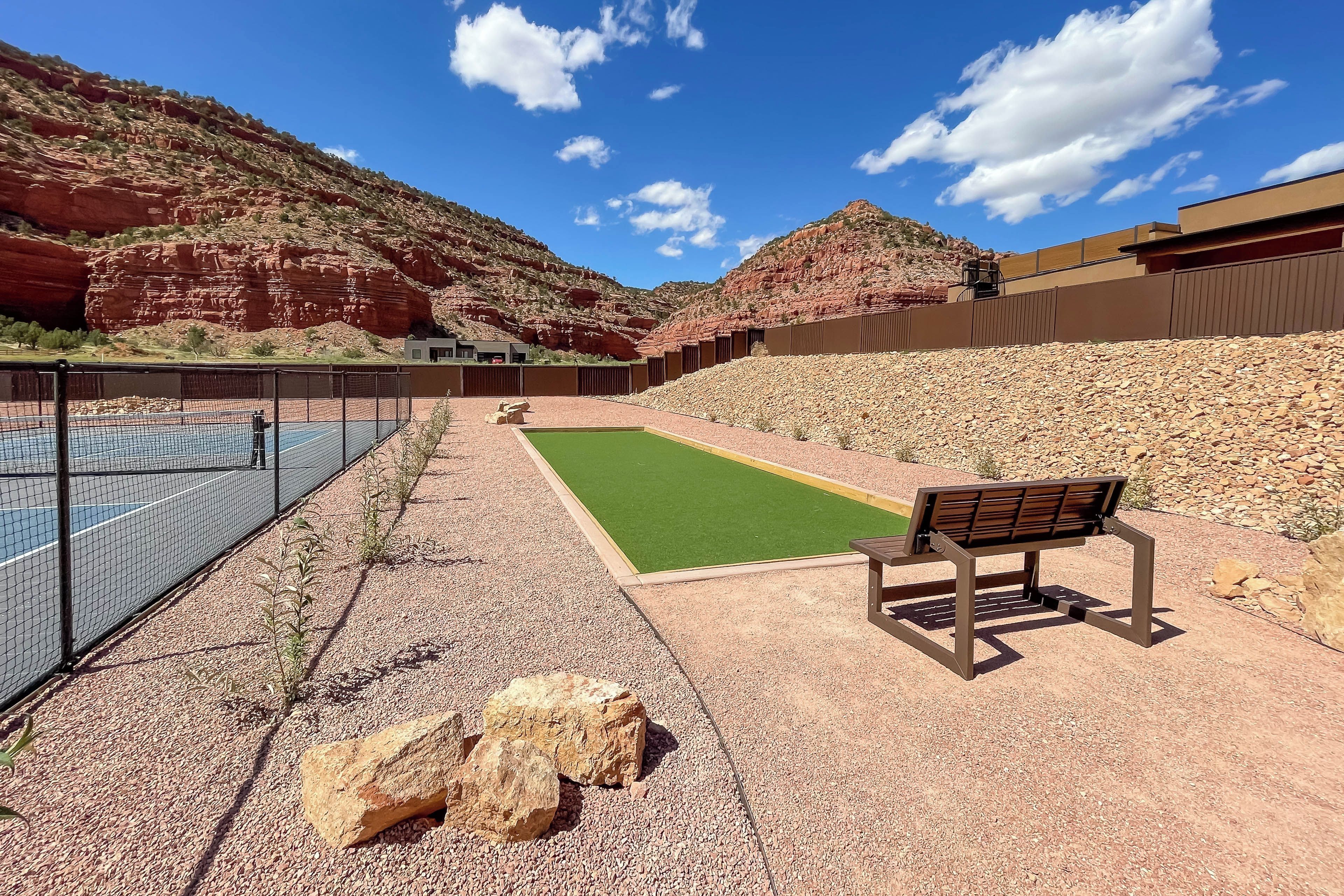 Un espace piscine avec un banc, entouré d’un paysage rocheux et sous un ciel dégagé.