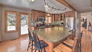 A spacious kitchen with wooden cabinets, a large island, and a view of the outdoors. - ~ 1 Mi to Downtown: Buena Vista Riverfront Escape! (Buena Vista)