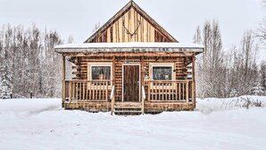 A wooden cabin with a front porch, a central door, and a triangular roof. - 'snowshoe Cabin' w/ Gas Grill: Fish & Hike! (Wasilla)
