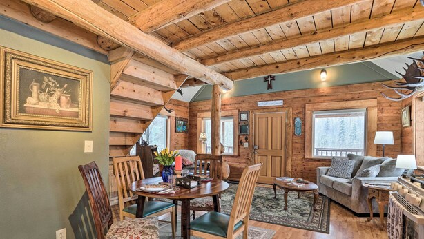 A cozy log cabin interior with a dining area, a sofa, and a fireplace. - 'snowshoe Cabin' w/ Gas Grill: Fish & Hike! (Wasilla)