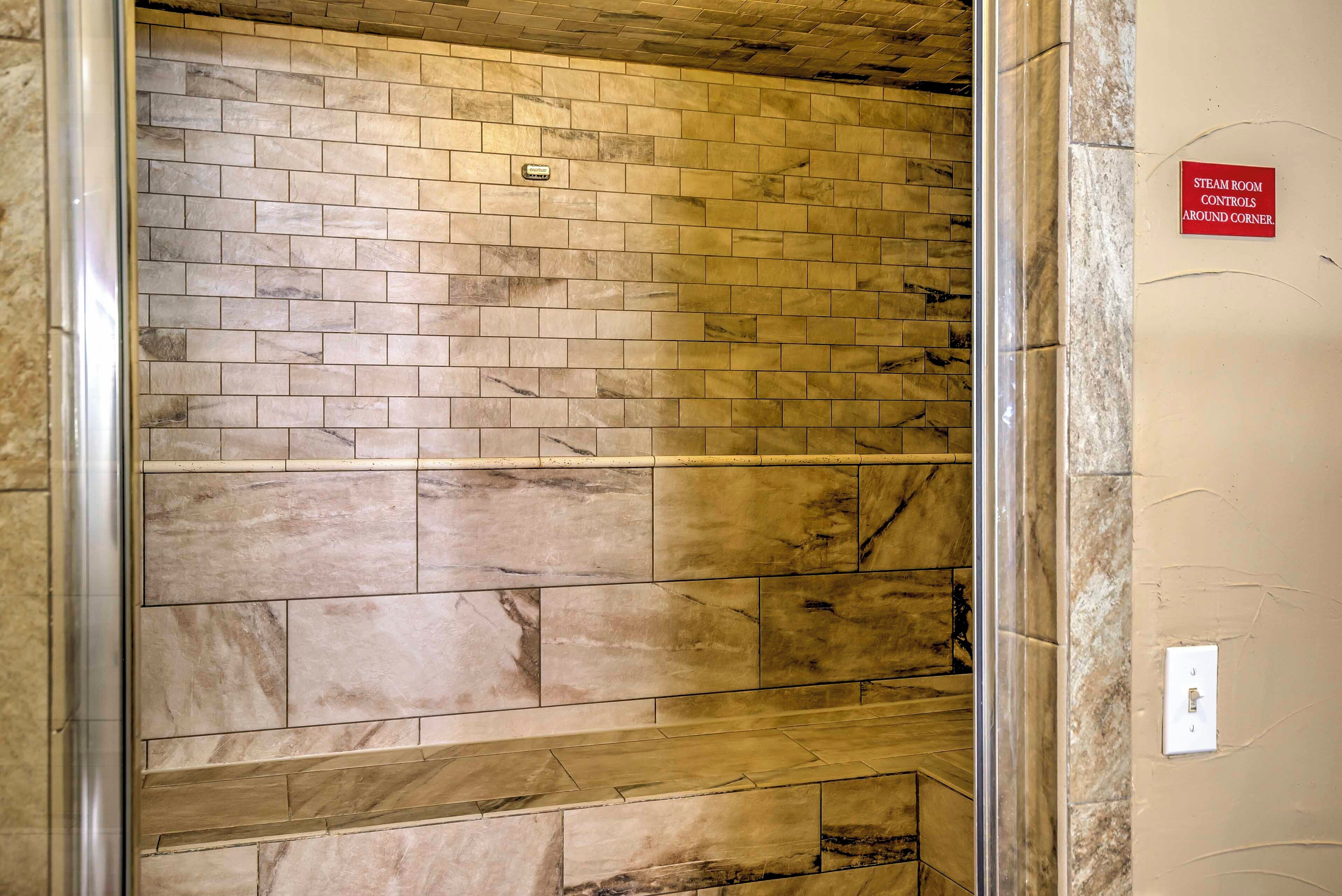 A steam room with controls around the corner.