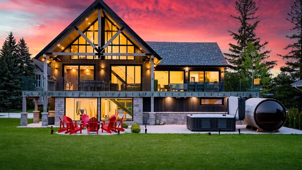 A modern two-story house with a large deck, outdoor seating, and a large barrel. - The Northern Escape HOT TUB & SAUNA! (blue mountain)