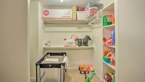 A child's play area with a crib, shelves with toys, and a toy car. - Roomy Texas Lake Retreat w/ Private Boat Ramp (Frankston)