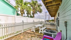 A fenced backyard with a picnic table, a fan, and a purple chair. - Near Port Aransas Beach: Condo w/ Pool Access (Port Aransas)