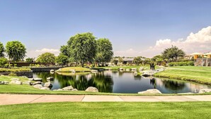 A serene outdoor area with a pond, well-maintained grass, and trees. - Resort Pool & Hot Tub: 55+ Indio Desert Oasis (Indio)