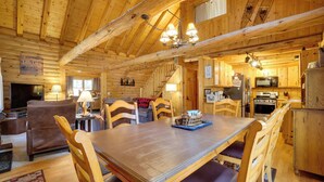 A wooden cabin interior with a dining area, kitchen, and living room. - Picturesque Log Cabin in Estes Park: 9 Mi. to Rmnp (Estes Park)