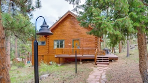 A log cabin with a porch, a wooden deck, and a stone pathway leading to the entrance. - Picturesque Log Cabin in Estes Park: 9 Mi. to Rmnp (Estes Park)
