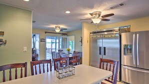 A kitchen with a large island, stainless steel appliances, ceiling fans, and wooden chairs. - Dock & Fire Pit: Waterfront Cedar Creek Lake Home (Kemp)