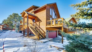 A wooden house with a balcony and a staircase leading to the entrance.