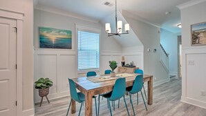 A dining area with a wooden table, teal chairs, and a chandelier. There are potted plants and a painting on the walls. - 4 Mi to Beach: Family-friendly Hilton Head Retreat (Hilton Head Island)