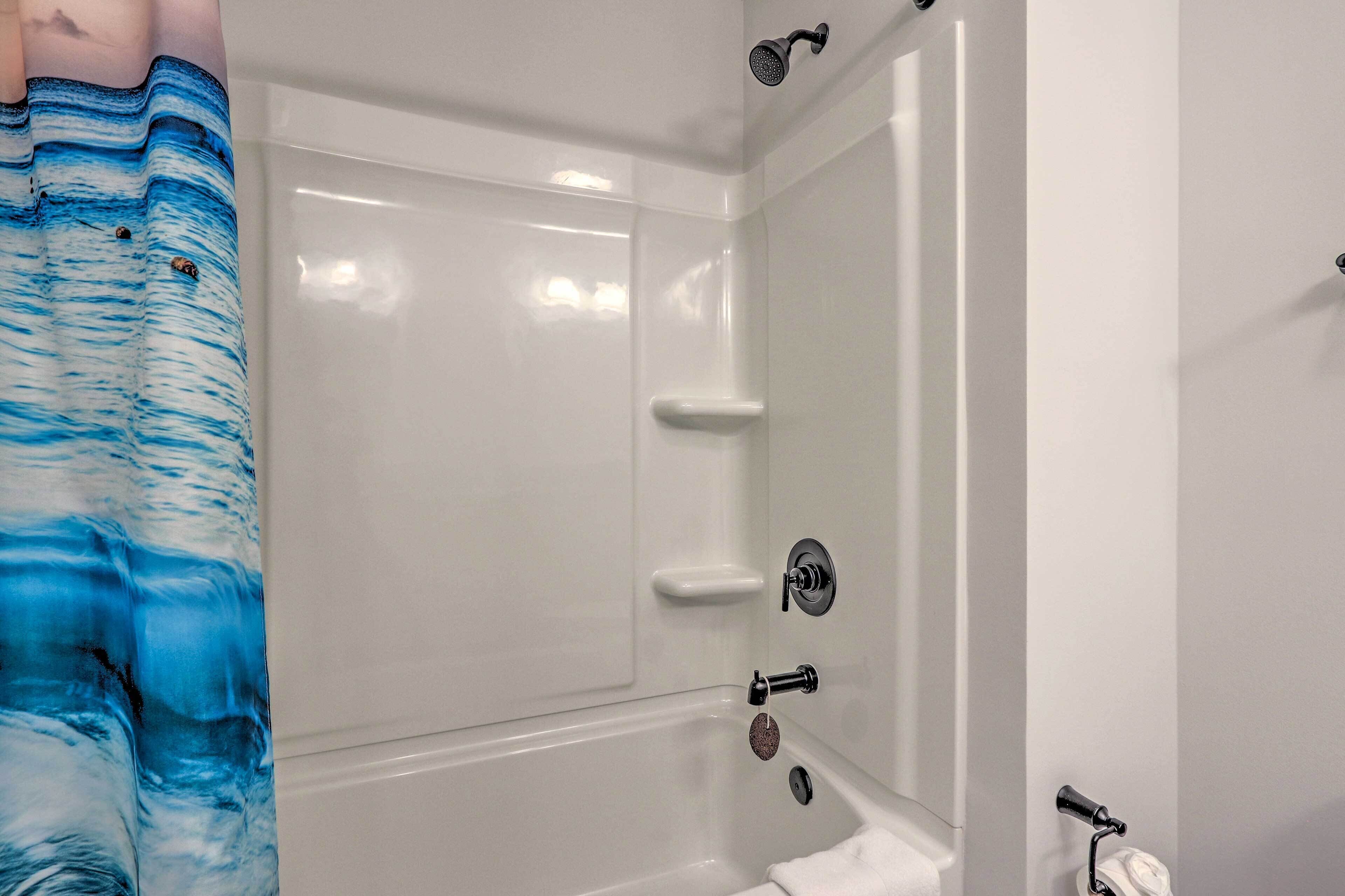 Un baño con bañera, ducha y retrete.