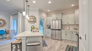 A modern kitchen with white cabinets, stainless steel appliances, and pendant lighting. - 4 Mi to Beach: Family-friendly Hilton Head Retreat (Hilton Head Island)