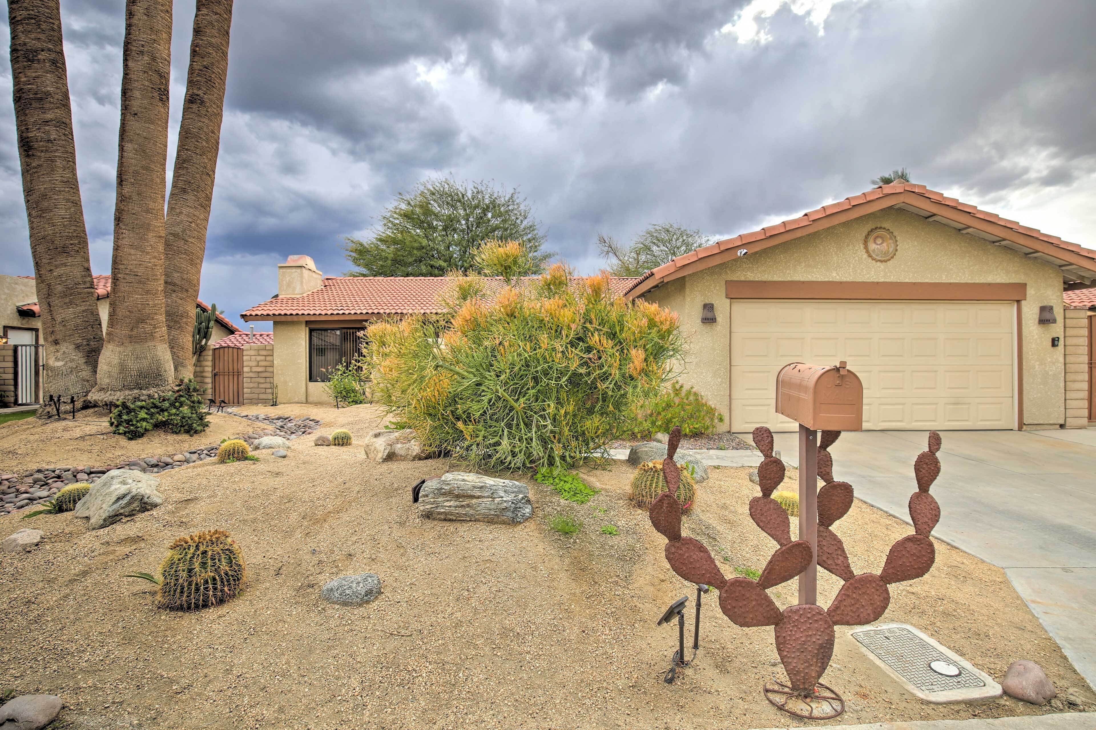 A residential area with a house, a garage, and a cactus sculpture in the front yard.