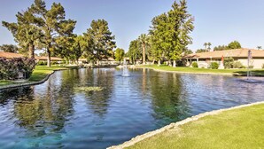 Une cour paisible avec un bassin central, entourée d’arbres majestueux et de pelouses bien entretenues.