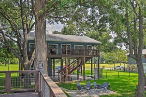 A two-story building with a covered patio area, outdoor seating, and a staircase leading to an upper level.