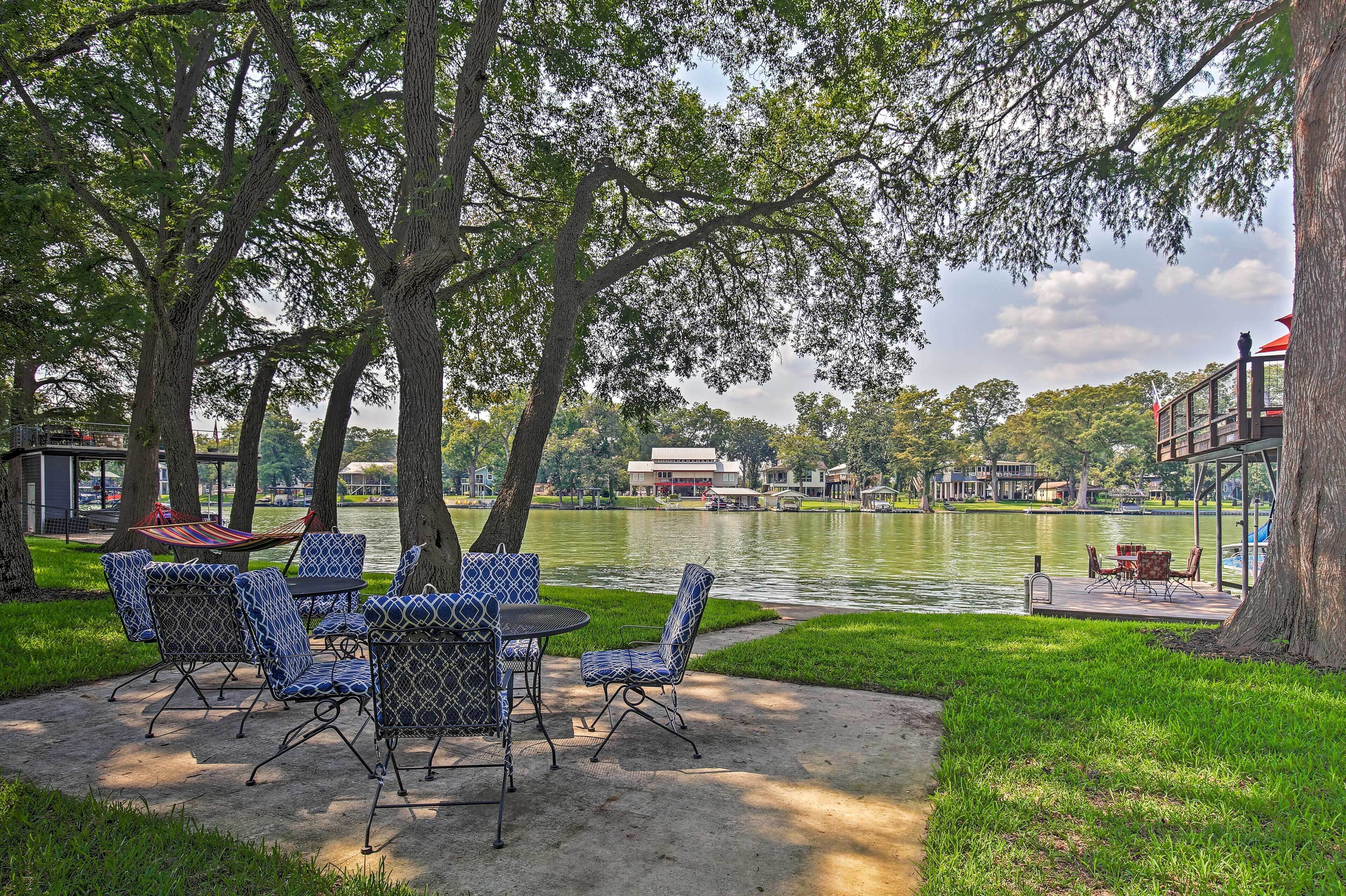 Une terrasse au bord du lac, avec des sièges extérieurs et une vue sur le lac.