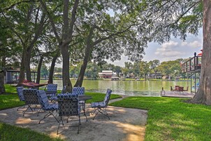 A lakeside patio with outdoor seating and a view of the lake.