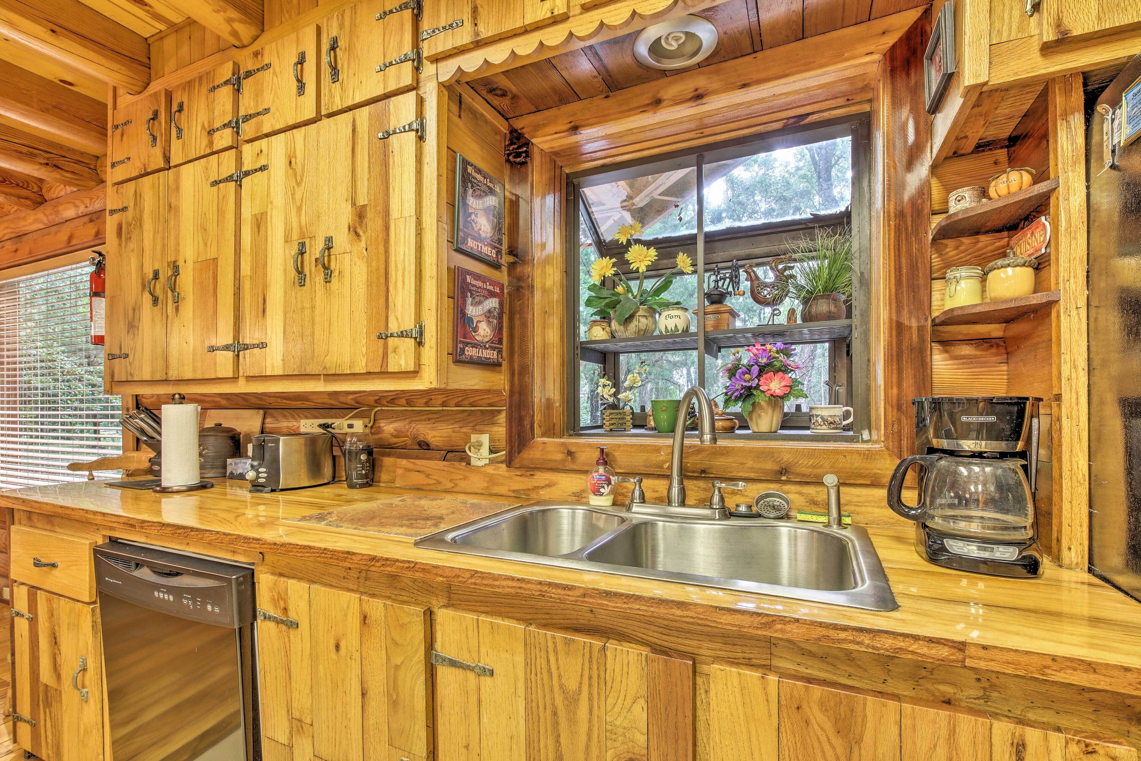 A wooden kitchen with a sink, dishwasher, and coffee maker.