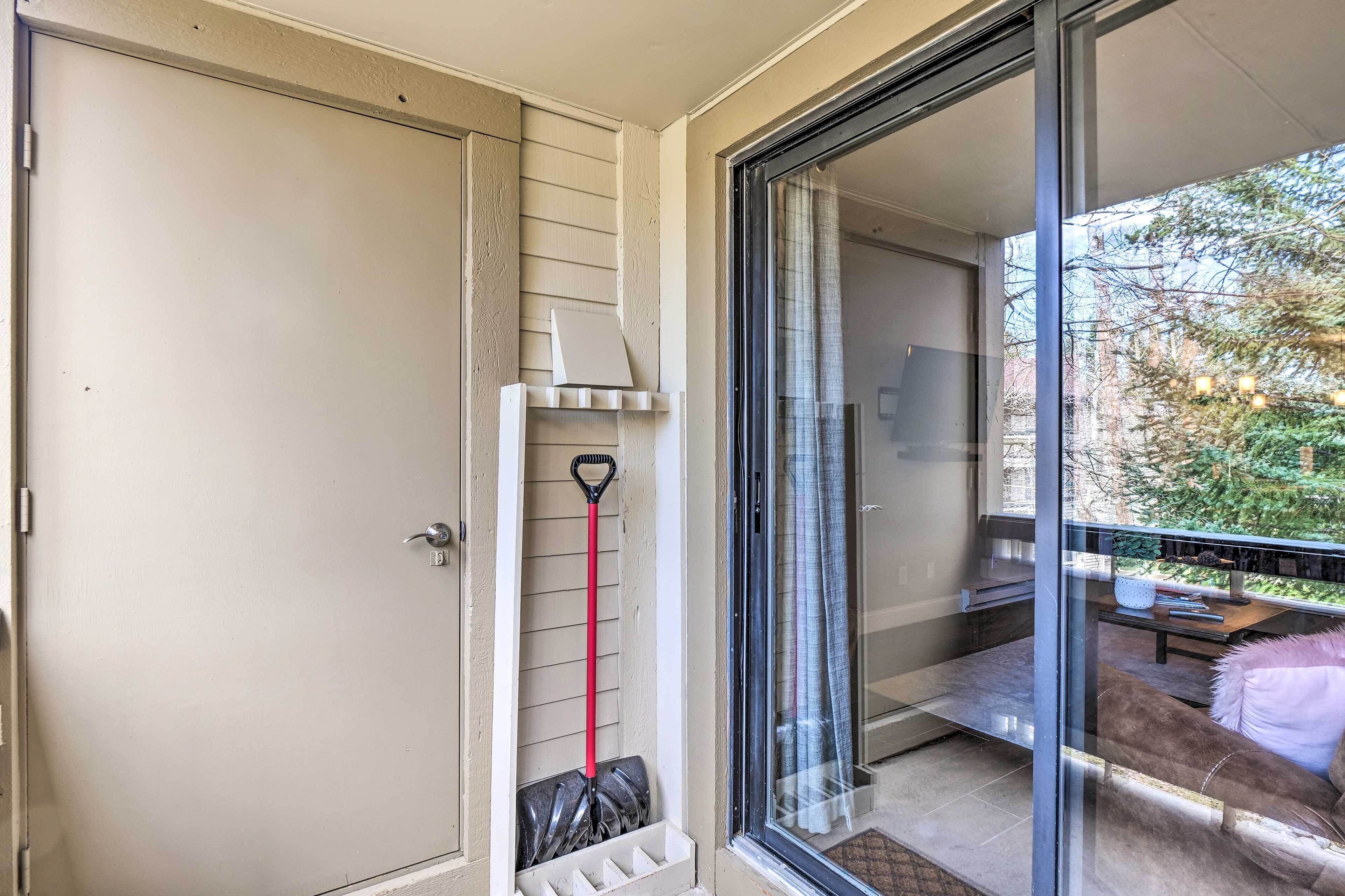 Eine Glastür mit Schiebeöffnung führt zu einem Balkon mit Esstisch und Sofa.