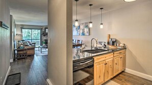 Een moderne keuken met een vaatwasser, houten kastjes en hanglampen.