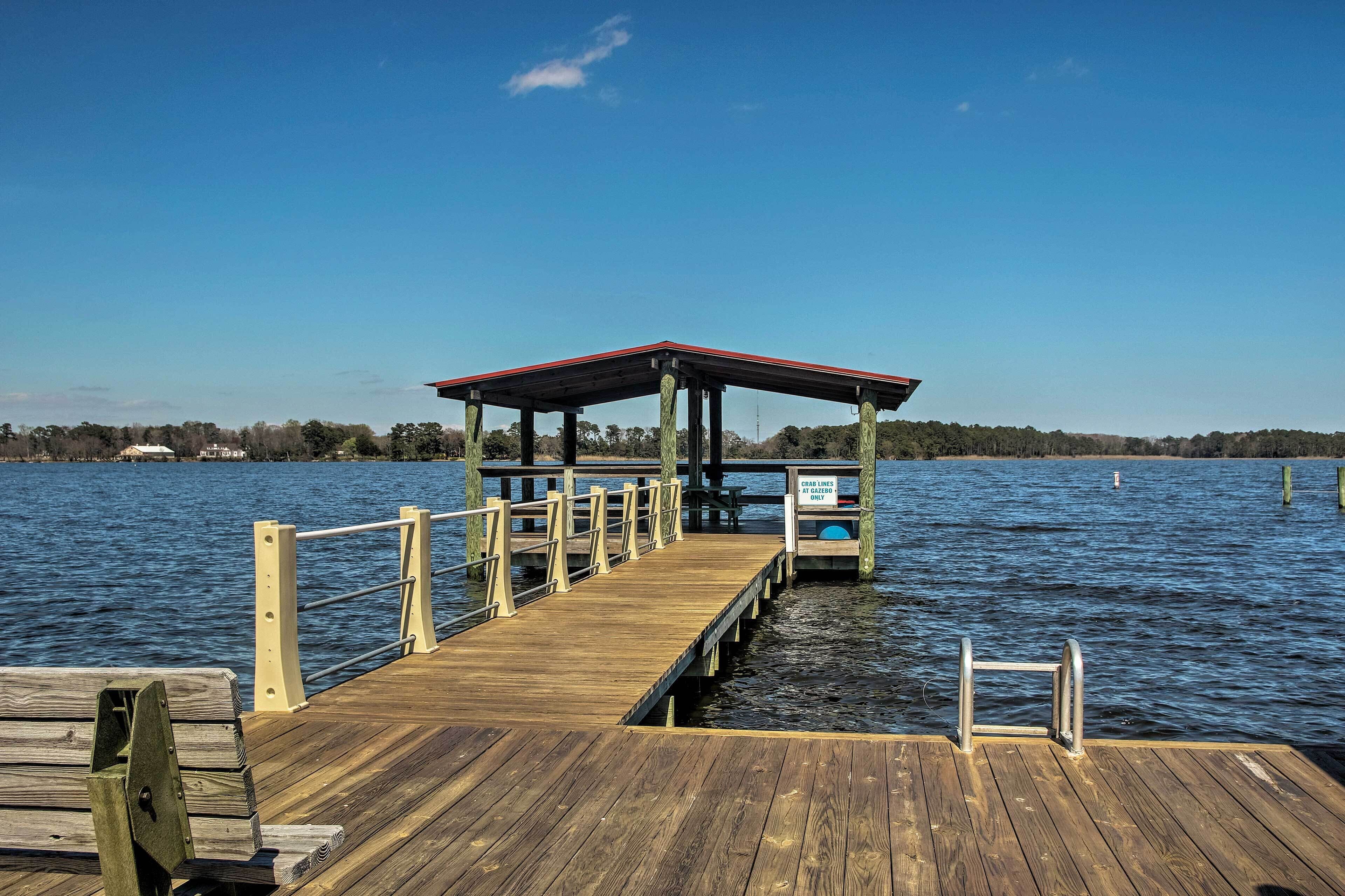 A wooden pier leading to a covered area with a sign indicating 'CRAB LINES AT GAZEBO ONLY'.