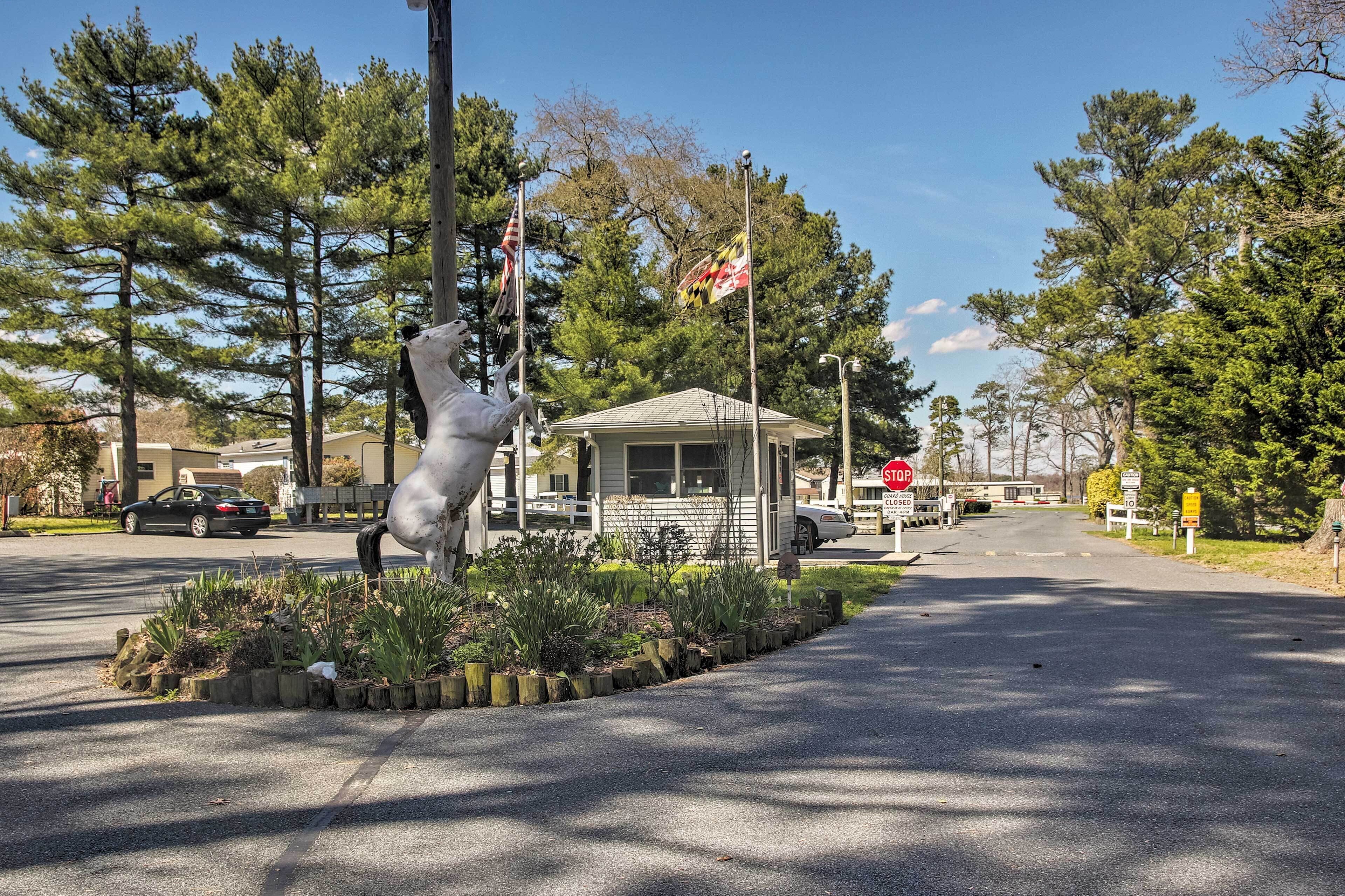 Eine Straße mit einer Pferdestatue, einem kleinen Gebäude und einem Stoppschild.