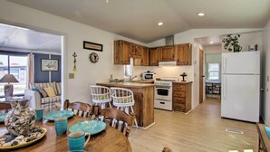 Una cocina amplia con armarios de madera, un comedor con mesa y sillas de madera y un refrigerador.