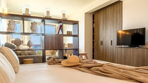 Ein modernes Schlafzimmer mit einem großen Bett, einem Fernseher und einem Einbauschrank.