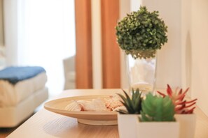 A wooden table with a round tray, a potted plant, and a small succulent.