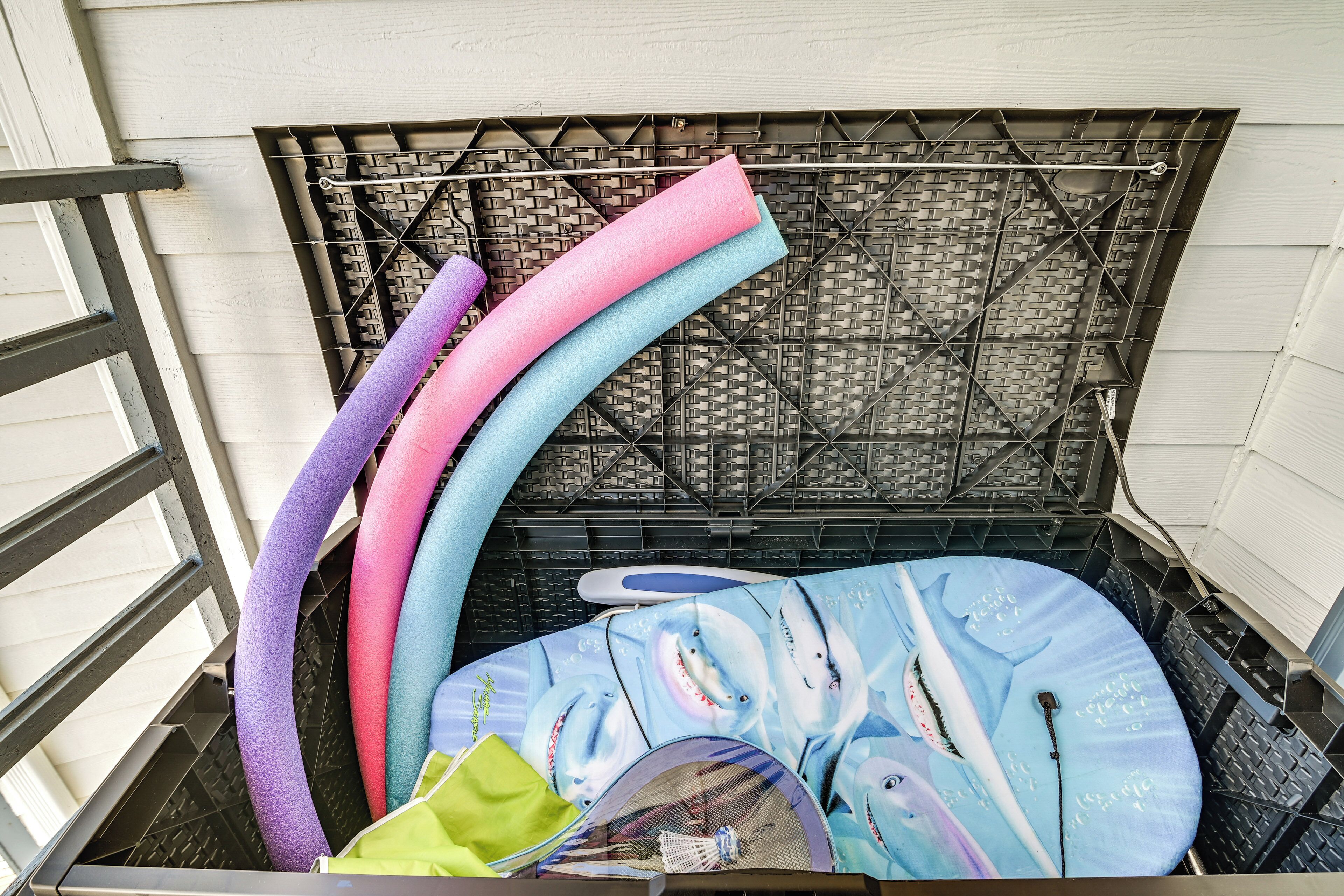 A storage area with colorful mats and a blue mat with shark designs.