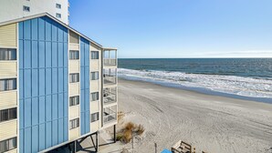 A beachfront hotel with a modern design, featuring a large blue facade and multiple balconies. - Cozy Beachfront Condo w/ Wifi, Views & Pool Access (Murrells Inlet)