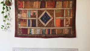 A quilt hanging on a wall with a white decorative panel below it. - Ca'Rosa, 500 years old, Super Central (Venezia)