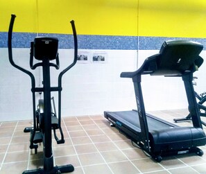 An indoor gym with exercise equipment including a treadmill and a stationary bike.