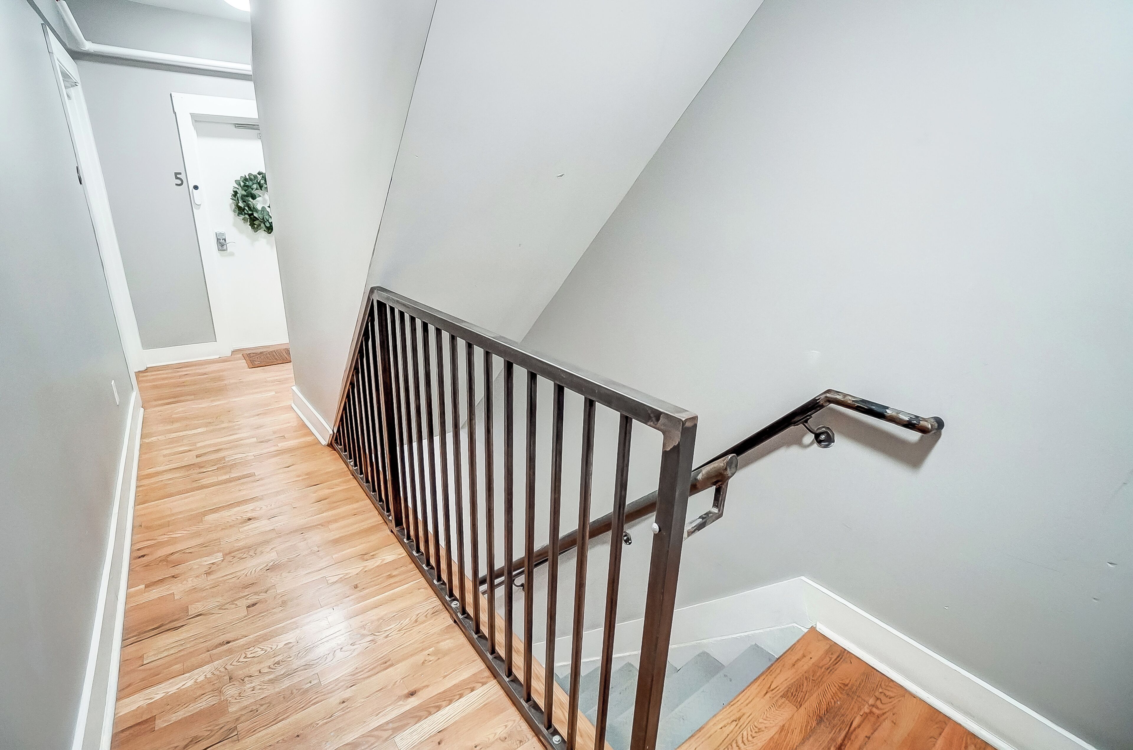 A staircase with a metal handrail and wooden steps.