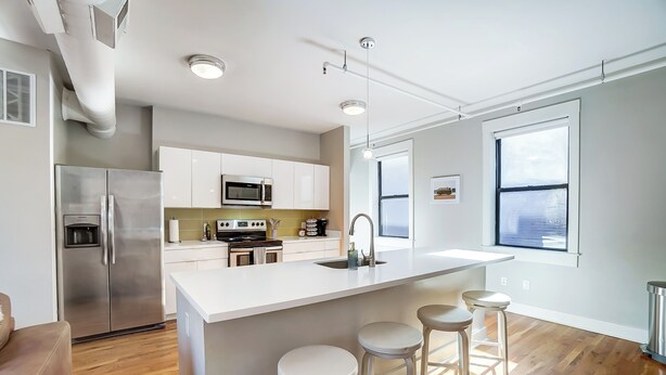 A modern kitchen with white cabinetry, stainless steel appliances, and a large island with bar stools. - 'the Republic Retreat' Walk to Washington Park! (Cincinnati)