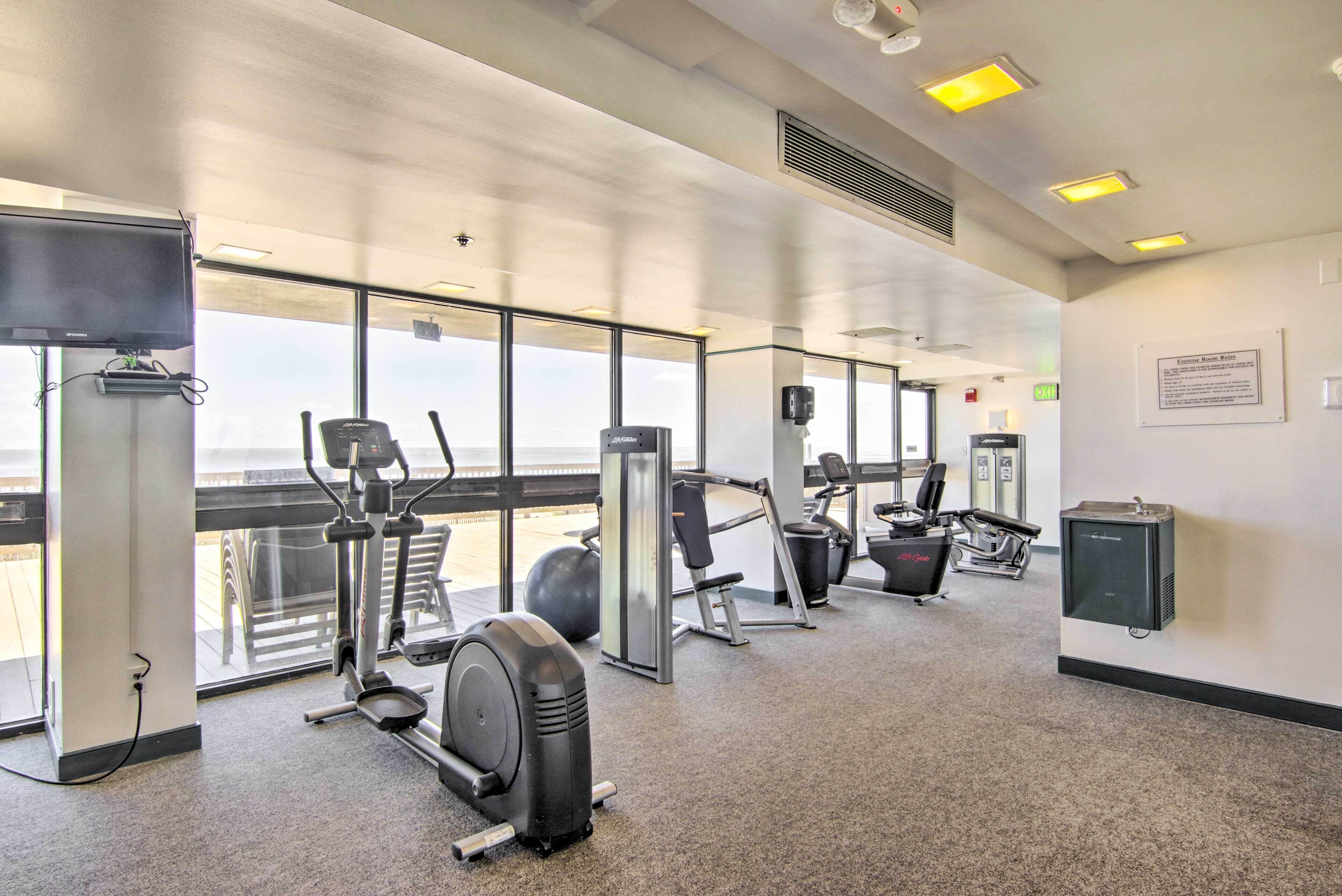 A gym with cardio machines, free weights, and a wall-mounted water dispenser.