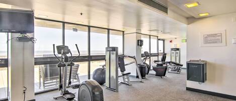 A gym with cardio machines, free weights, and a wall-mounted water dispenser.