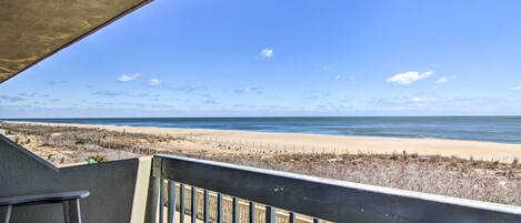 A balcony with a view of a beach and ocean.