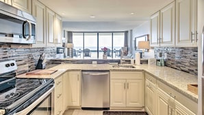 A modern kitchen with a stainless steel microwave, dishwasher, and granite countertops. - Indoor Pool & Views: Beachfront Ocean City Condo (Ocean City)
