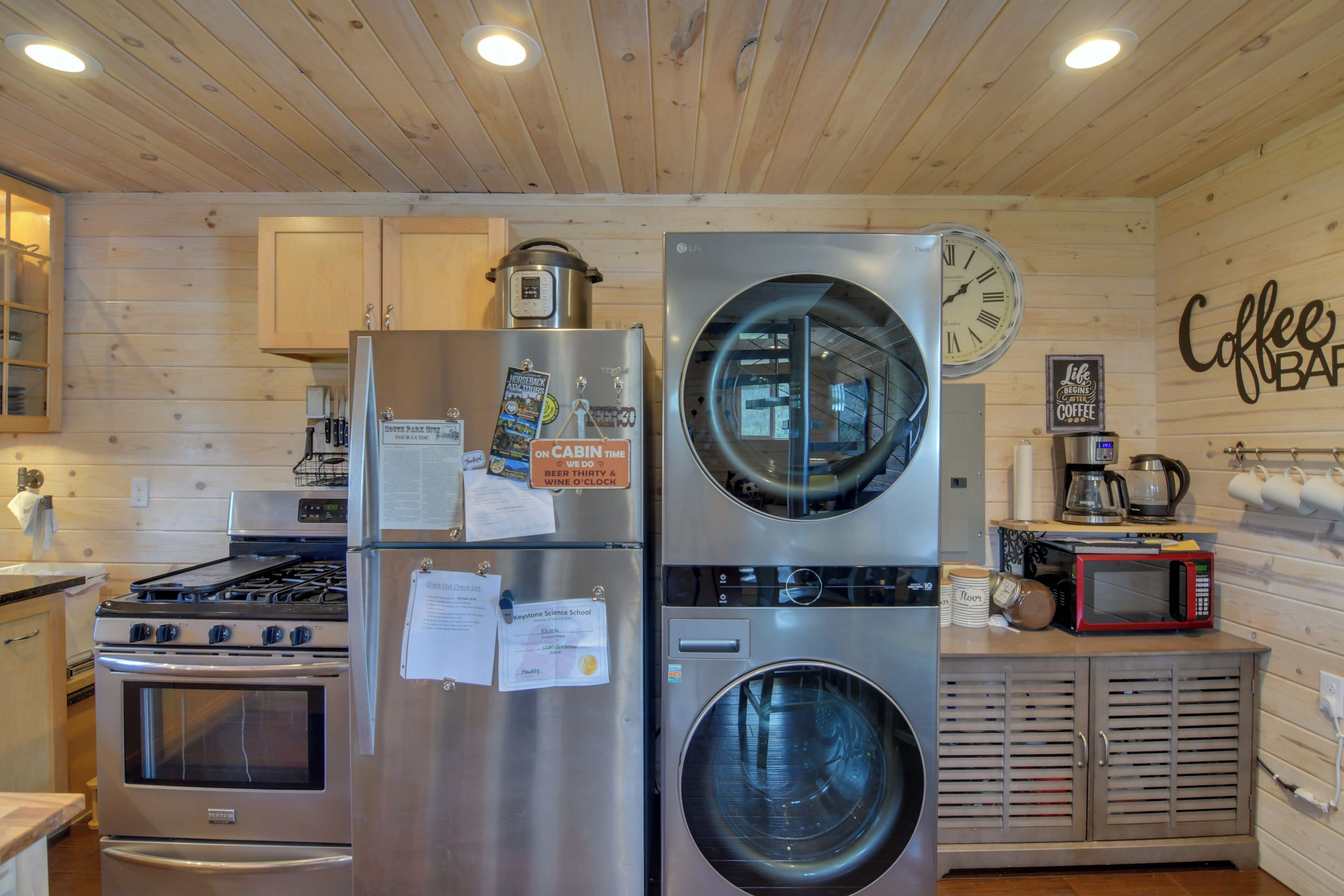 Una cocina compacta con electrodomésticos de acero inoxidable, lavadora y espacio para café.