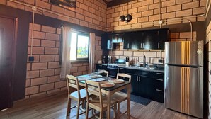 A kitchen with brick walls, wooden ceiling beams, and a stainless steel refrigerator. - Hotel & RV PARK Rosa Evelyn (San Quintin)